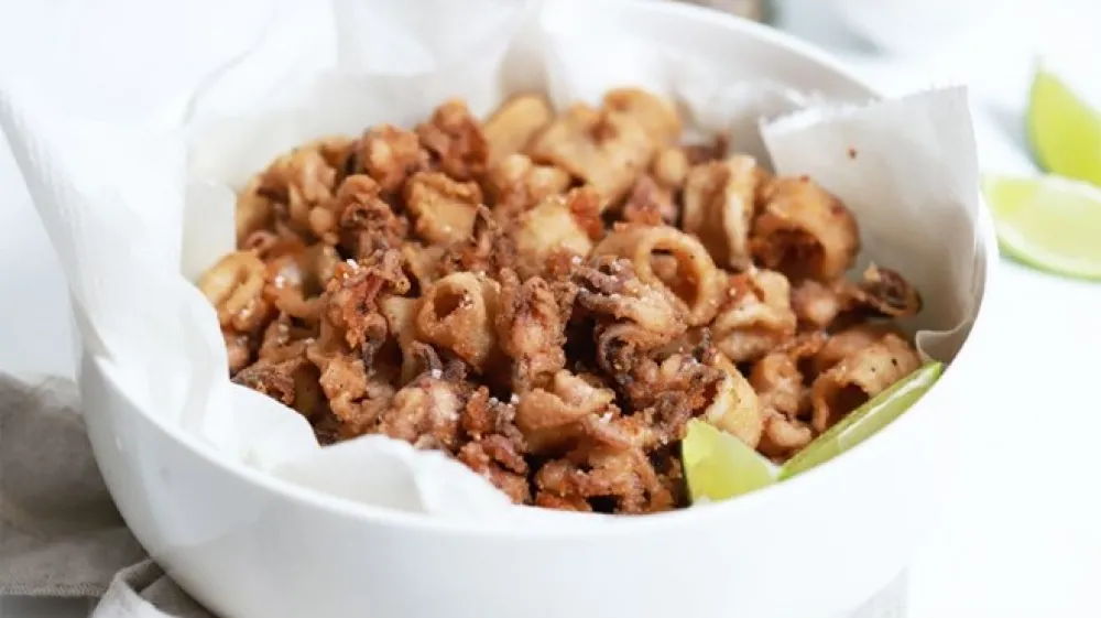 Kalamari, povaljani v odi&scaron;avljeni moki in na hitro ocvrti v vročem olju.