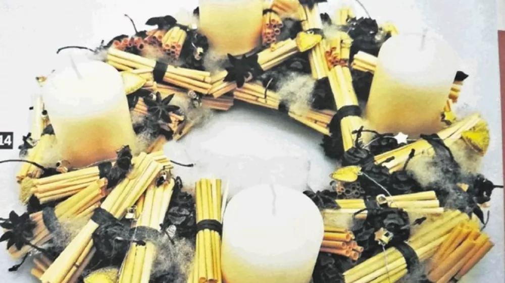 Venec s snopki iz slame je povit s kremastim krep papirjem.