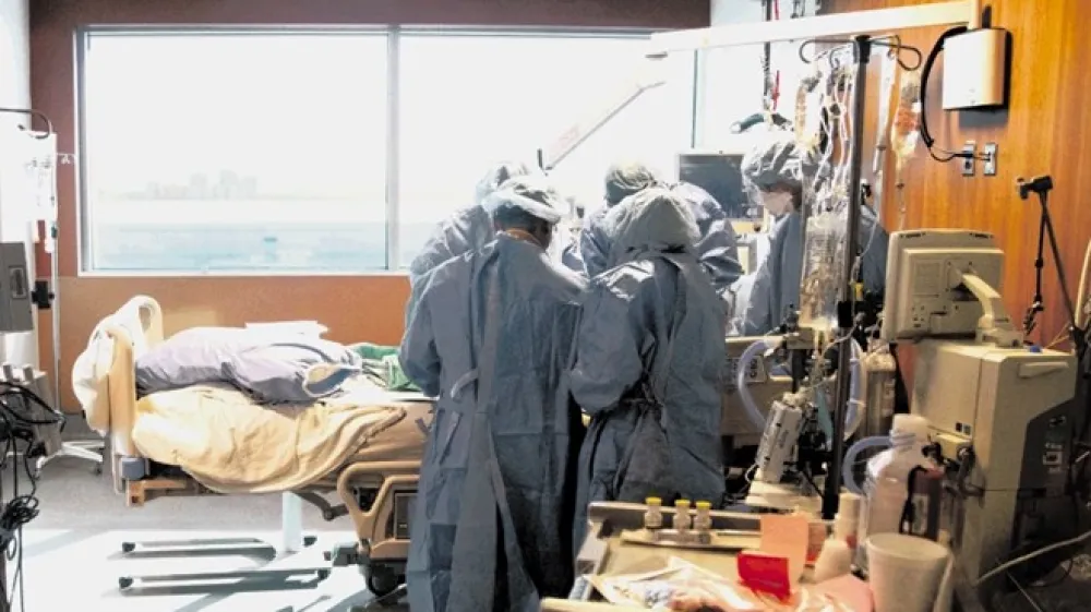Odrejene, zdaj skraj&scaron;ane  izolacije po okužbi nekateri ne spo&scaron;tujejo v prepričanju, da  omikron povzroča le blažji prehlad.  To ne drži, tudi zdaj obstaja tveganje za težji potek covida. Na fotografiji: V bolni&scaron;nici  v Torontu  intubirajo  pacienta z omikronom.