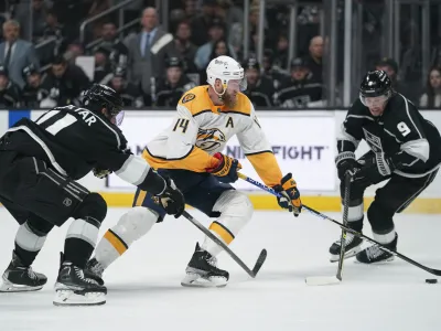 Los Angeles Kings center Anze Kopitar (11) and center Adrian Kempe (9) defend against Nashville Predators defenseman Mattias Ekholm (14) during the third period of an NHL hockey game Tuesday, March 22, 2022, in Los Angeles. (AP Photo/Ashley Landis)