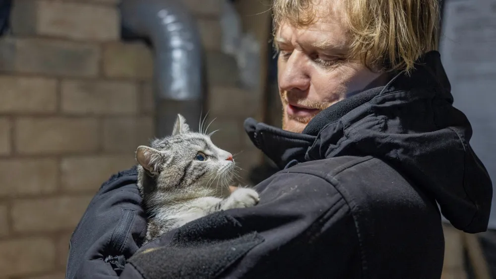 Ukrainian photographer Maksim Levin holds a cat near the line of separation from Russian-backed separatists in Luhansk region, Ukraine January 6, 2022. Picture taken January 6, 2022. REUTERS/Stanislav Kozliuk