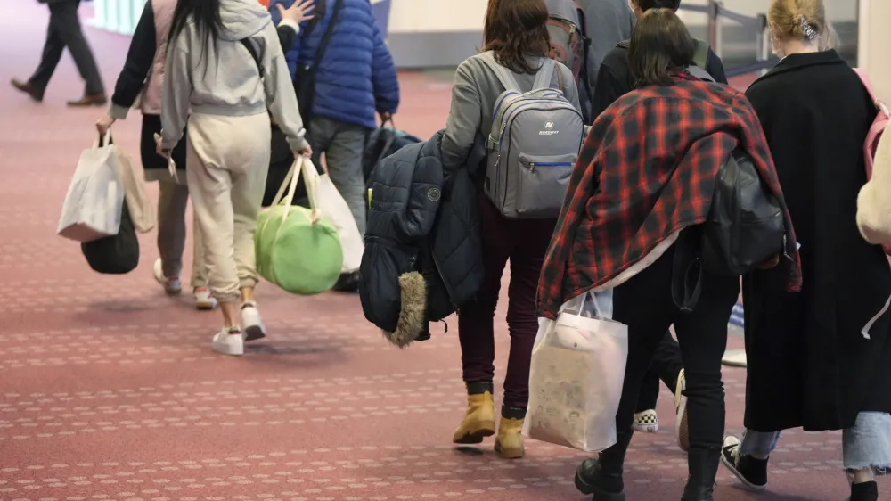 Ukrainian refugees walk upon arrival from Poland at the Haneda Airport Tuesday, April 5, 2022, in Tokyo. Japanese Foreign Minister Yoshimasa Hayashi returned from Poland on Tuesday with 20 Ukrainians displaced by Russia's ongoing war on their country as Tokyo seeks to play a greater role in international support for Ukraine. (AP Photo/Eugene Hoshiko)