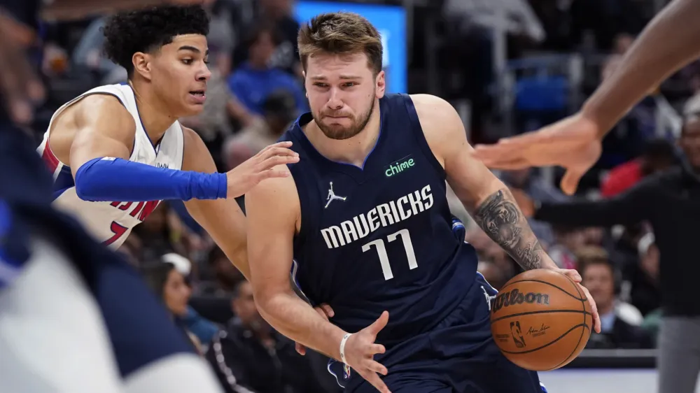 Dallas Mavericks guard Luka Doncic (77) is defended by Detroit Pistons guard Killian Hayes (7) during the second half of an NBA basketball game, Wednesday, April 6, 2022, in Detroit. (AP Photo/Carlos Osorio)