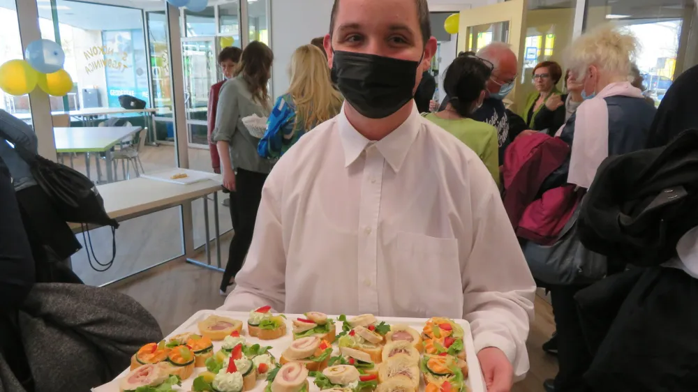 Nejc Gor&scaron;in Fabjan, zaposlen v Hi&scaron;i kulinarike preko programa integrirane zaposlitve, je ob otvoritvi novih prostorov novome&scaron;kega Centra Sonček skrbno postregel s pijačo in prigrizki.