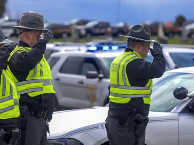 Law enforcement personnel salute during a funeral for Bluffton Police Officer Dominic Francis, Friday, April 8, 2022, in Bluffton, Ohio. Francis was killed in the line of duty during a police chase on March 31. (Richard Parrish/The Lima News via AP)