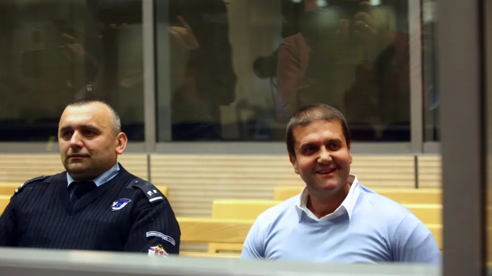 Alleged Balkan drugs boss Darko Saric, who surrendered to Serbian police last week after almost five years on the run, smiles inside a court in Belgrade March 24, 2014. Saric, 43, one of the most wanted figures in the crime-riddled Balkan region, faces 13 indictments including the trafficking of 5.7 tonnes of cocaine from Latin America and the laundering of 22 million euros in Serbia. He denied on Monday any involvement in trafficking cocaine from Latin America to Europe and told his first court hearing that the charges against him had been fabricated. REUTERS/Djordje Kojadinovic (SERBIA - Tags: CRIME LAW DRUGS SOCIETY) - GM1EA3O1SKA01