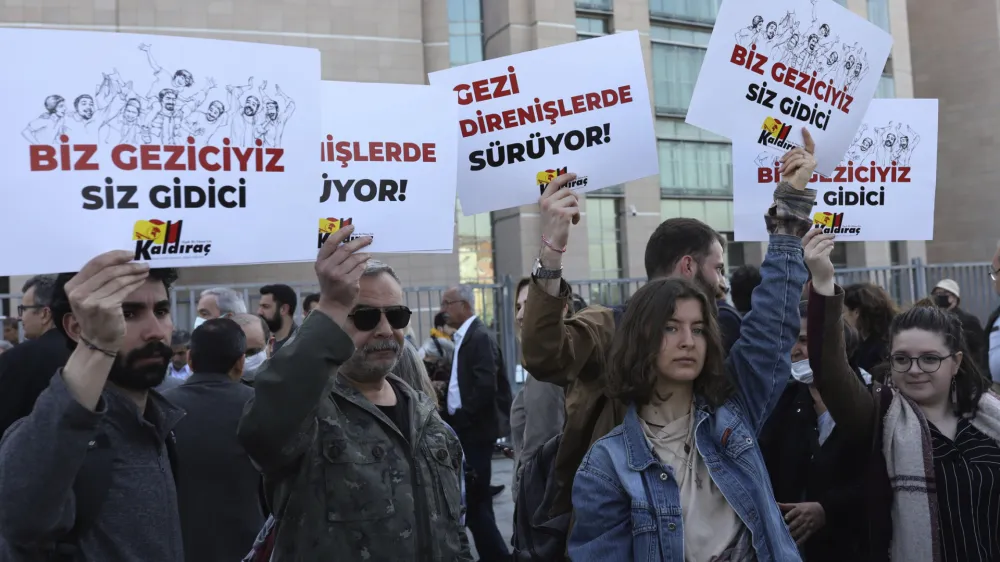 People react after a Turkish court sentenced prominent Turkish civil rights activist and philanthropist Osman Kavala to life in prison without parole, finding him guilty of attempting to overthrow the government in connection with the 2013 mass anti-government protests, in Istanbul, Monday, April 25, 2022. The court in Istanbul also sentenced seven other defendants, including 71-year-old architect Mucella Yapici, to 18 years in prison each for "aiding" the attempt. It ordered that the activists, who were not in custody, be immediately arrested, the state-run Anadolu Agency reported. The placards read: "You will go." (AP Photo)