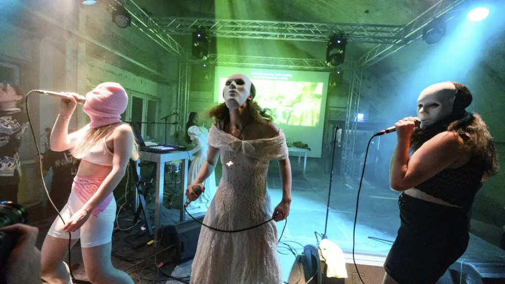 Diana Burkot, from left, Maria Alyokhina and Olga Borisova perform at the concert of the anti-Kremlin and feminist band Pussy Riot held at Funkhaus Berlin, in Berlin, Germany, Thursday, May 12, 2022. The 33-year-old Alyokhina had only recently fled Russia. Based on the book "Riot Days" by Alyokhina, the "Pussy Riot Anti-War Tour" presented a performance project consisting of music, theater and video recordings. (Bernd von Jutrczenka/dpa via AP)