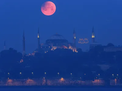 A full moon rises above the iconic Haghia Sophia in Istanbul, Turkey, early Monday, May 16, 2022. (AP Photo/Mucahid Yapici)