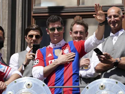 Bayern's Robert Lewandowski gestures to supporters as he stands on the balcony of the town hall at Marienplatz square celebrating the 31th Bundesliga title at the German Bundesliga in Munich, Germany, Sunday, May 15, 2022. (AP Photo/Matthias Schrader)