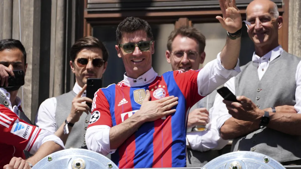 Bayern's Robert Lewandowski gestures to supporters as he stands on the balcony of the town hall at Marienplatz square celebrating the 31th Bundesliga title at the German Bundesliga in Munich, Germany, Sunday, May 15, 2022. (AP Photo/Matthias Schrader)