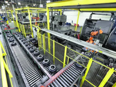 In this Friday, Jan. 11, 2013, photo, brake drums roll down a conveyor belt to a station which robotically balances the drum at Webb Wheel Products in Cullman, Ala. Webb Wheel hasn't added a factory worker in three years, though it's making 300,000 more drums annually, a 25 percent increase, because of robots. (AP Photo/Dave Martin)