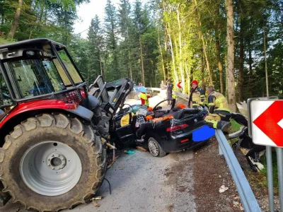 Osebni avto se je zagozdil pod traktor