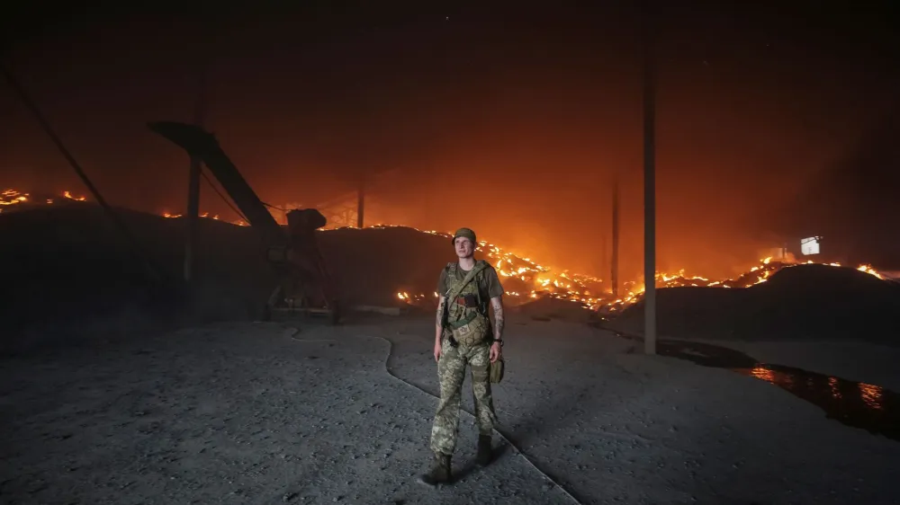 A Ukrainian serviceman walks as seeds burn in a grain silos after it was shelled repeatedly, amid Russia's invasion of Ukraine, in Donetsk region, Ukraine May 31, 2022. REUTERS/Serhii Nuzhnenko