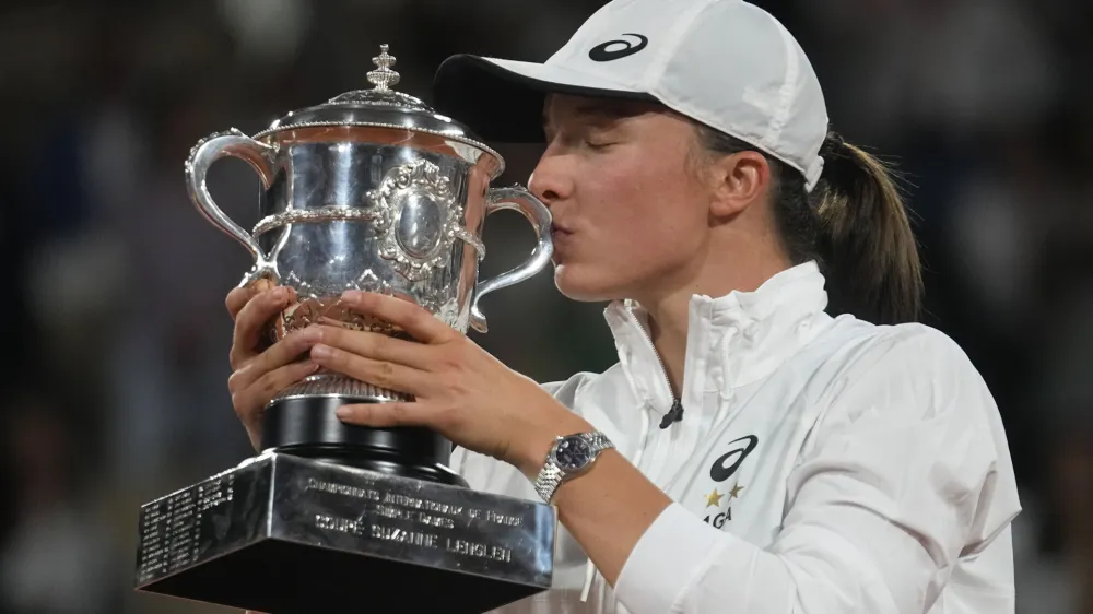 Poland's Iga Swiatek kisses the trophy after winning the final against Coco Gauff of the U.S. in two sets, 6-1, 6-3, at the French Open tennis tournament in Roland Garros stadium in Paris, France, Saturday, June 4, 2022. (AP Photo/Michel Euler)