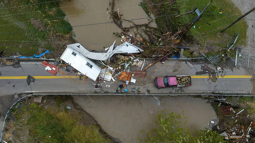 29 July 2022, US, Whitesburg: People work to clear a house resting on a bridge near the Whitesburg Recycling Center in Letcher County following catastrophic flooding in Kentucky. Photo: Ryan C. Hermens/Lexington Herald-Leader via ZUMA/dpa