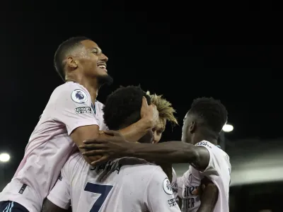 Arsenal players celebrate after Crystal Palace's Marc Guehi scores an own goal past his goalkeeper during the English Premier League soccer match between Crystal Palace and Arsenal at Selhurst Park stadium in London, Friday, Aug. 5, 2022. (AP Photo/Ian Walton)