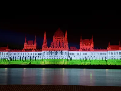 The colors of the Hungarian flag illuminate the Parliament building to mark the national holiday celebrating Hungary's statehood in Budapest, Hungary, Saturday, Aug. 20, 2022. State founder St. Stephen I, the first king of Hungary was crowned in 1000 A.D. (Peter Lakatos/MTI via AP)