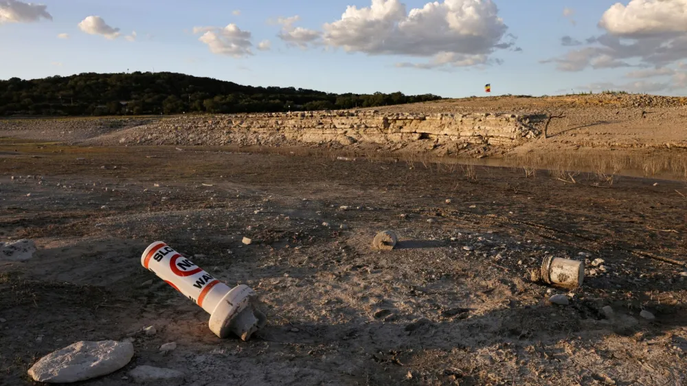 FILE PHOTO: A bouy normally used to mark "No wake" zones sits on dry land at Medina Lake outside of San Antonio as majority of Texas experiences drought amid an extreme heat wave hitting the state, in Medina County, Texas, U.S., June 18, 2022. REUTERS/Jordan Vonderhaar/File Photo