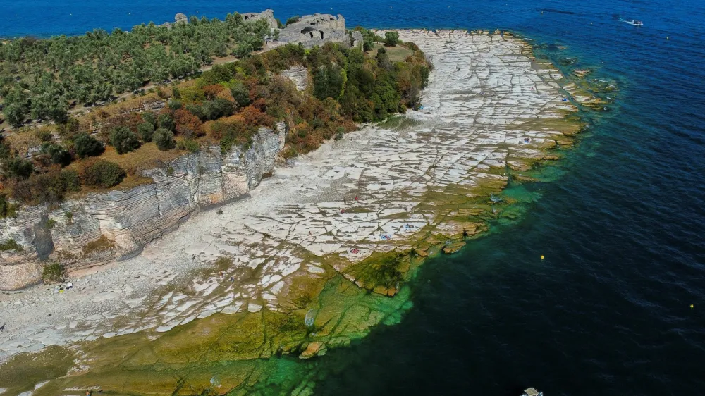 Pogled na italijansko jezero Garda, kjer so zaradi na površju marsikje skale. 
