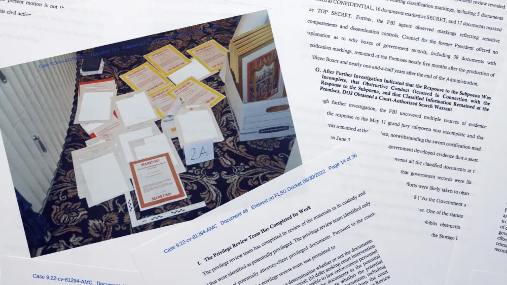 Pages from a Department of Justice court filing on Aug. 30, 2022, in response to a request from the legal team of former President Donald Trump for a special master to review the documents seized during the Aug. 8 search of Mar-a-Lago, are photographed early Wednesday, Aug. 31, 2022. Included in the filing was a FBI photo of documents that were seized during the search. (AP Photo/Jon Elswick)