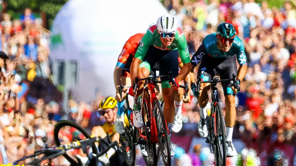 06 September 2022, Spain, Tomares: Danish cyclist Mads Pedersen (C) of Trek-Segafredo sprints to the finish line of stage 16 of the 77th edition of the 'Vuelta a Espana', Tour of Spain cycling race, a 189,4 km km flat stage from Sanlucar de Barrameda to Tomares as Slovenian Primoz Roglic of Jumbo-Visma (L) lies injured after crashing. Photo: David Pintens/BELGA/dpa