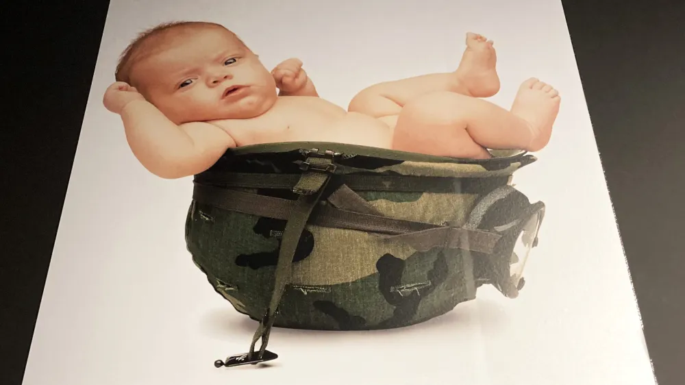 V času vojne med Srbijo in Bosno je bil na oglasu dojenček v voja&scaron;ki čeladi. Ta naj bi reprezentiral eno od najbolj grozljivih voja&scaron;kih strategij: etnično posilstvo, katerega cilj je etnično či&scaron;čenje. 