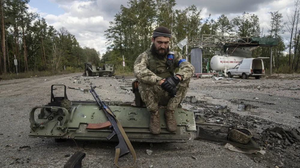 A Ukrainian serviceman smokes a cigarette after he finds and identifies a dead body of a comrade in recently recaptured town of Lyman, Ukraine, Monday, Oct. 3, 2022. (AP Photo/Evgeniy Maloletka)