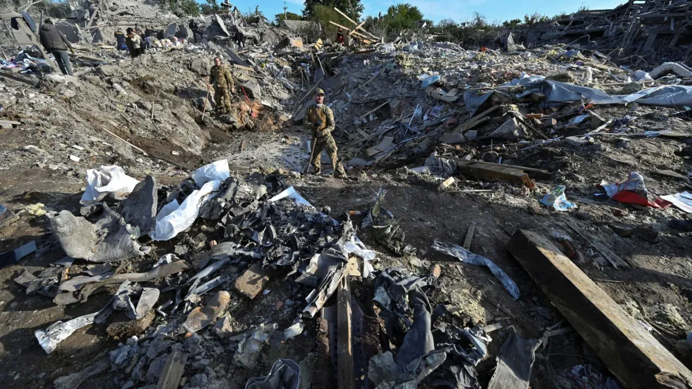 Ukrainian service members inspect a crater at a site of a residential area heavily damaged by a Russian missile strike, amid Russia's attack on Ukraine, in Zaporizhzhia, Ukraine October 9, 2022. REUTERS/Stringer