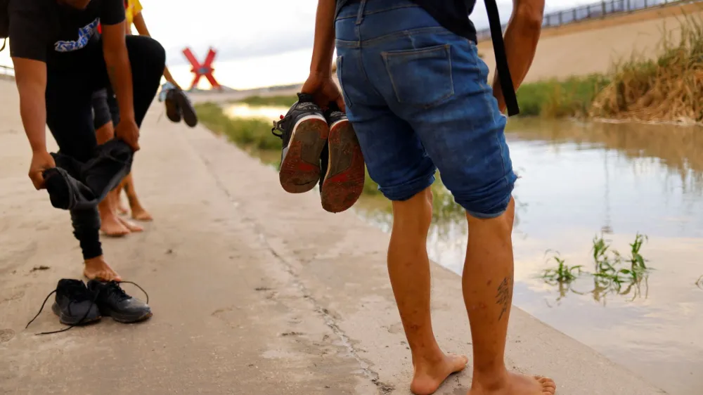 Asylum-seeking migrants from Venezuela proceed to cross the Rio Bravo river to turn themselves in to U.S Border Patrol agents to request asylum in El Paso, Texas, U.S., in Ciudad Juarez, Mexico October 6, 2022. REUTERS/Jose Luis Gonzalez