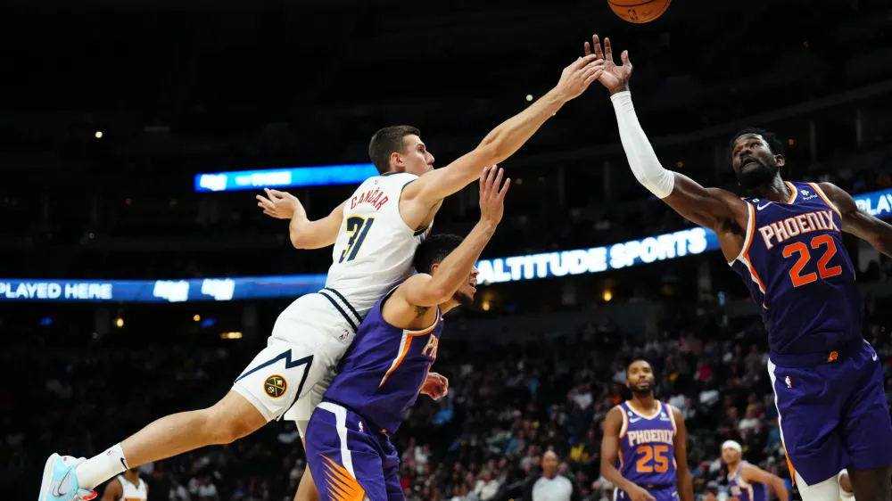 Oct 10, 2022; Denver, Colorado, USA; Phoenix Suns center Deandre Ayton (22) and guard Devin Booker (1) and Denver Nuggets forward Vlatko Cancar (31) reach for the ball in the second half at Ball Arena. Mandatory Credit: Ron Chenoy-USA TODAY Sports