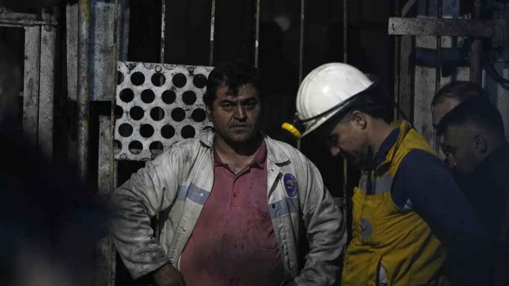 Miners and rescue members wait in front of the mine in Amasra, in the Black Sea coastal province of Bartin, Turkey, Saturday, Oct. 15, 2022. Officials say a deadly explosion occurred inside a coal mine in northern Turkey, trapping dozens of miners. (AP Photo/Khalil Hamra)