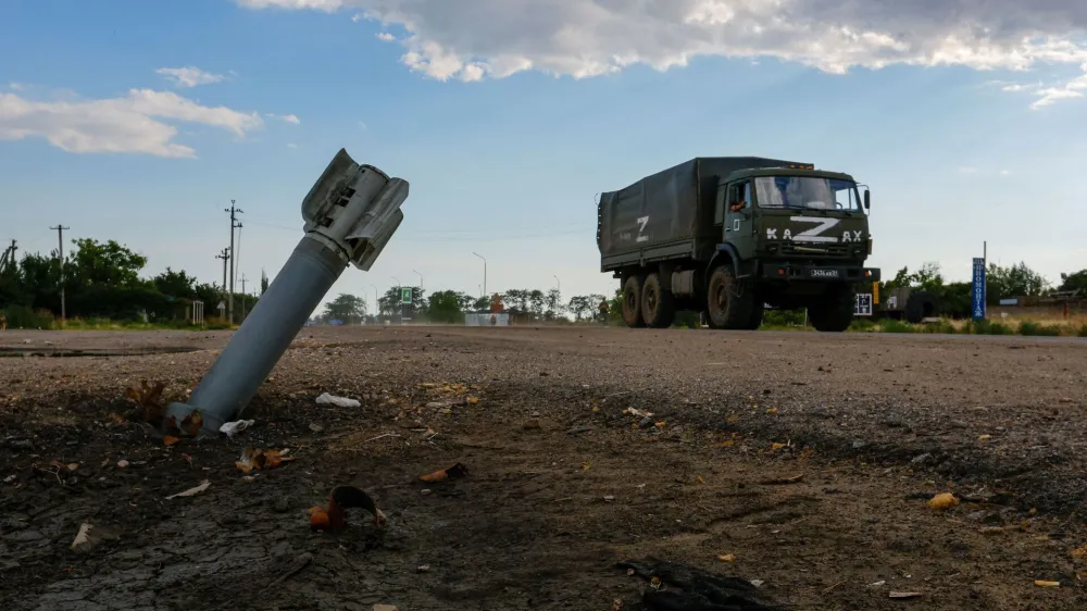 A Russian military truck drives past an unexploded munition during Ukraine-Russia conflict in the Russia-controlled village of Chornobaivka, Ukraine July 26, 2022. REUTERS/Alexander Ermochenko