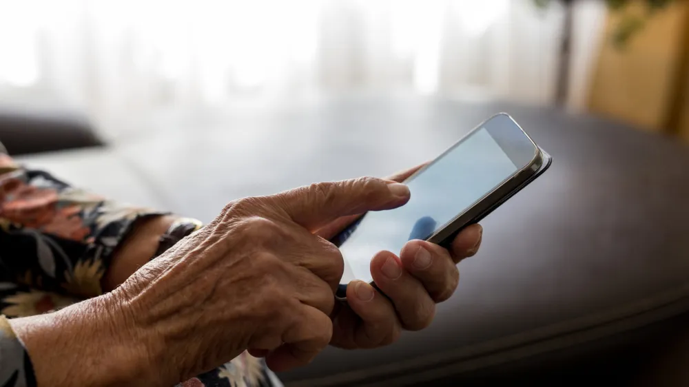 ﻿Old woman hands with mobile phone, closeup shot