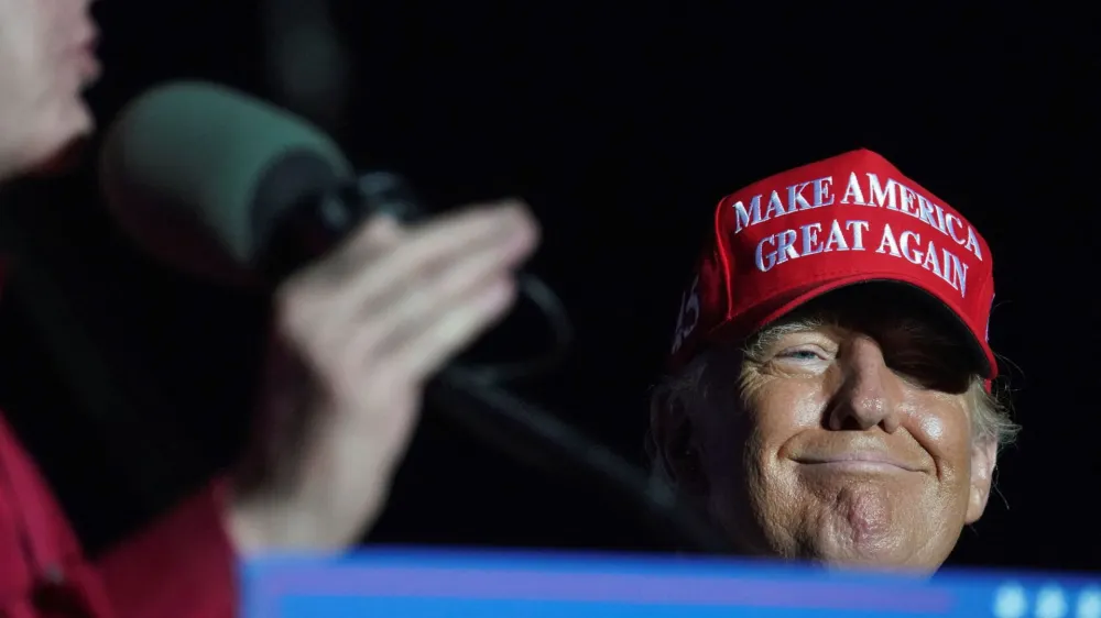 FILE PHOTO: Former U.S. President Donald Trump reacts as Lieutenant Governor of Texas Dan Patrick speaks during a rally in Robstown, Texas, U.S., October 22, 2022. REUTERS/Go Nakamura/File Photo