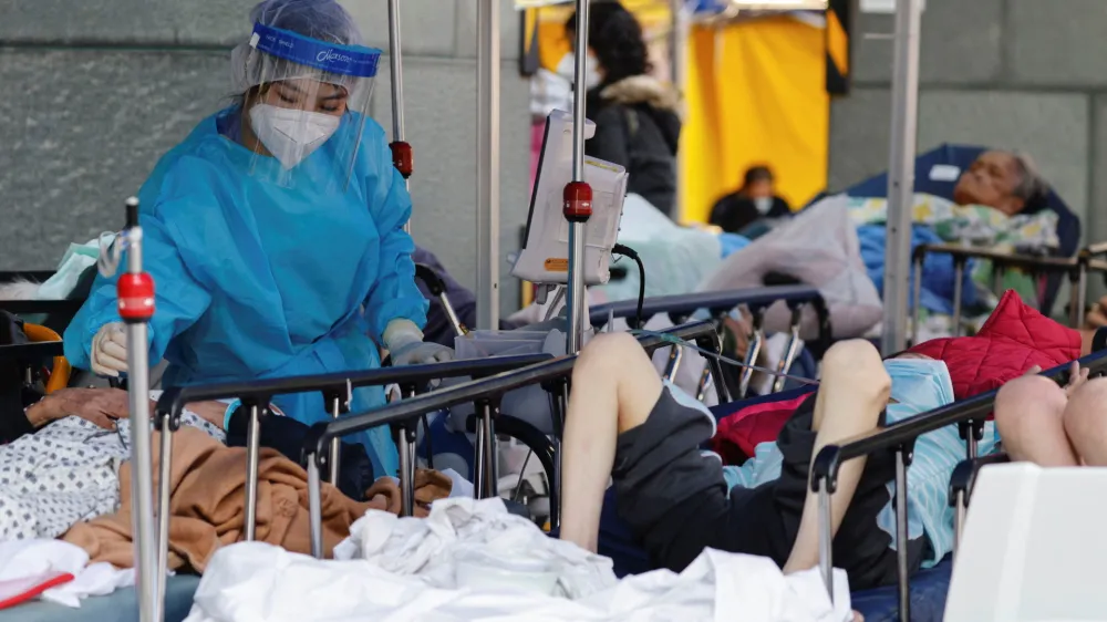 A medical worker wearing personal protective equipment (PPE) works at a makeshift coronavirus disease (COVID-19) treatment area, outside a hospital in Hong Kong, China, February 27, 2022. REUTERS/Tyrone Siu
