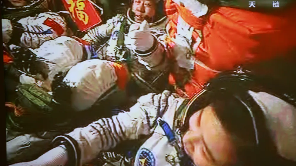 In this image made off the monitor screen at the Beijing Aerospace Flight Control Center and released by China's Xinhua News Agency, China's astronauts Jing Haipeng, center, Liu Wang, left, and Liu Yang sit inside the Shenzhou-9 manned spacecraft while conducting docking with the Tiangong-1 space lab module Monday afternoon, June 18, 2012, 343 kilometers (213 miles) above Earth. (AP Photo/Beijing Aerospace Control Center via Xinhua) NO SALES