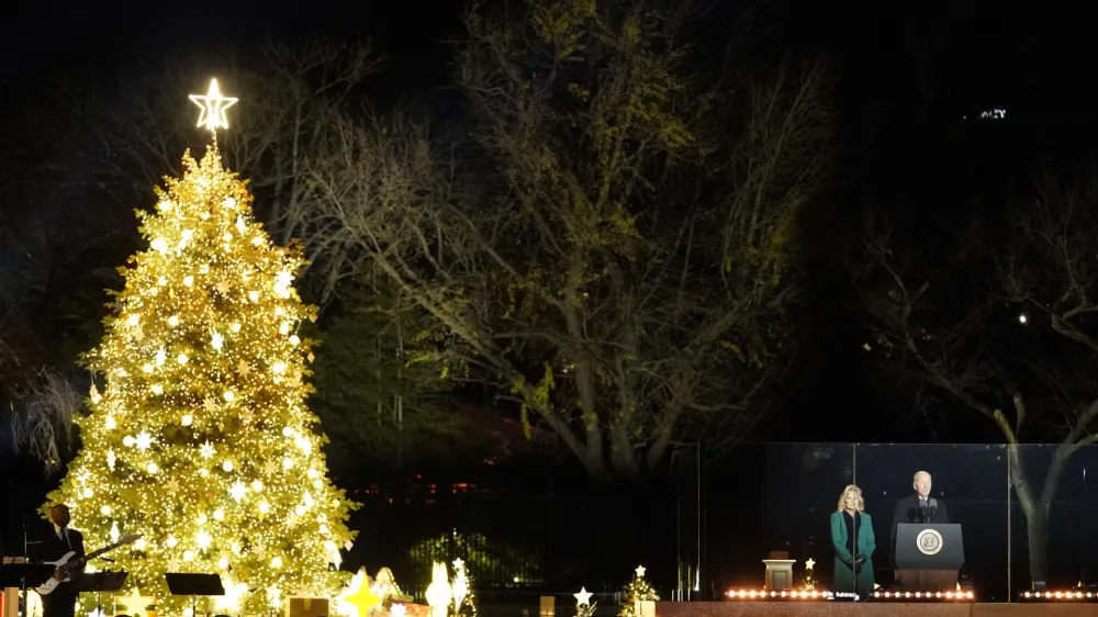 President Joe Biden speaks as first lady Jill Biden listens during the National Christmas Tree lighting ceremony on the Ellipse, near the White House in Washington, Wednesday, Nov. 30, 2022. (AP Photo/Alex Brandon)