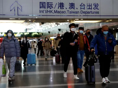 FILE PHOTO: Travellers walk with their luggage at Beijing Capital International Airport, amid the coronavirus disease (COVID-19) outbreak in Beijing, China December 27, 2022. REUTERS/Tingshu Wang/File Photo