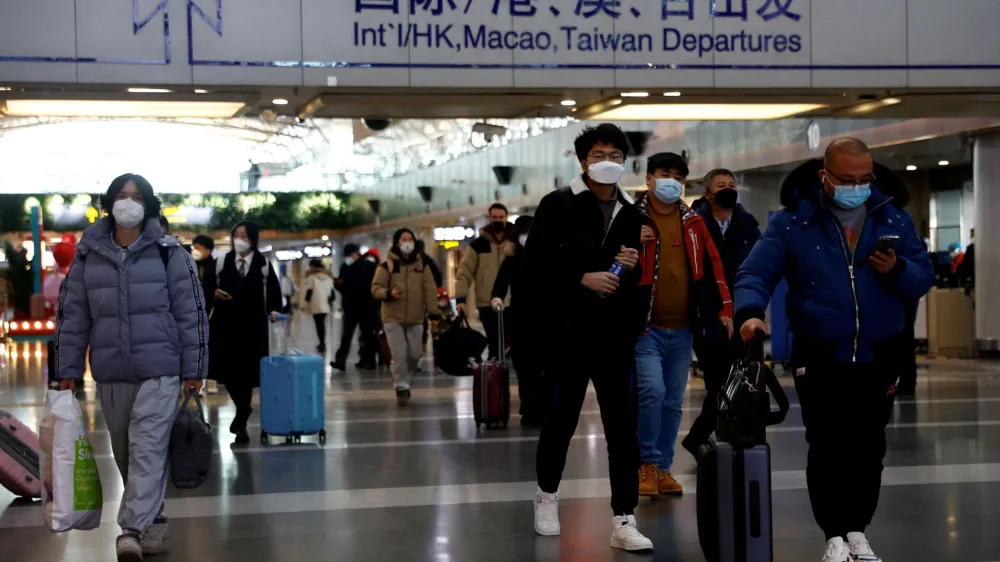 FILE PHOTO: Travellers walk with their luggage at Beijing Capital International Airport, amid the coronavirus disease (COVID-19) outbreak in Beijing, China December 27, 2022. REUTERS/Tingshu Wang/File Photo