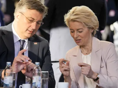 Croatia's Prime Minister Andrej Plenkovic and Ursula von der Leyen, President of the European Commission, inspect Croatian euro coins in Zagreb, Croatia, Sunday, Jan. 1, 2023. Croatia switched to the shared European currency, the euro, and removed dozens of border checkpoints to join the world's largest passport-free travel area. (AP Photo/Darko Bandic)