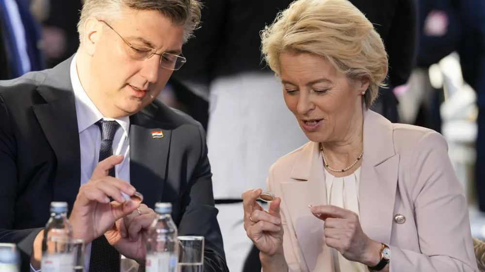 Croatia's Prime Minister Andrej Plenkovic and Ursula von der Leyen, President of the European Commission, inspect Croatian euro coins in Zagreb, Croatia, Sunday, Jan. 1, 2023. Croatia switched to the shared European currency, the euro, and removed dozens of border checkpoints to join the world's largest passport-free travel area. (AP Photo/Darko Bandic)