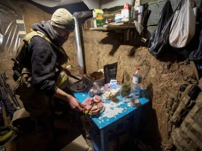 A Ukrainian service member prepares food in a shelter near their position at a frontline, amid Russia's attack on Ukraine, in Donetsk region, Ukraine January 1, 2023. REUTERS/Anna Kudriavtseva