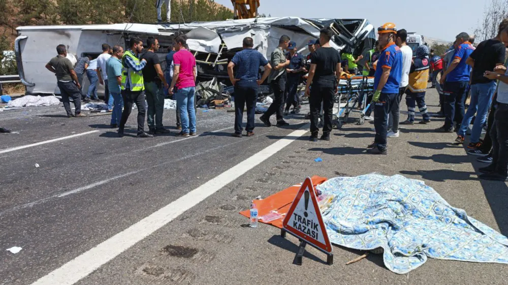 Emergency and rescue teams attend the scene after a bus crash accident on the highway between Gaziantep and Nizip, Turkey, Saturday, Aug. 20, 2022. Officials in southern Turkey say at least 15 people were killed when a passenger bus collided with emergency teams handling an earlier road accident. (IHA via AP)