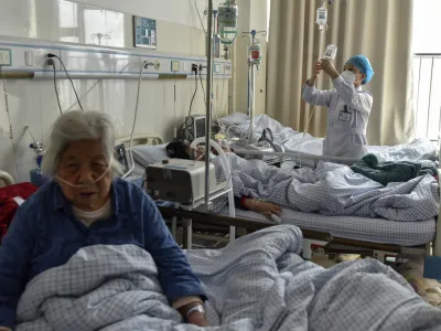 Elderly patients with COVID symptoms receive intravenous drips at the emergency ward of a hospital in Fuyang in central China's Anhui province on Jan. 4, 2023. China's healthcare authorities declined to include Pfizer's COVID-treatment drug in a national reimbursement list that would have allowed patients to get it at a cheaper price throughout the country, saying it was too expensive. (Chinatopix Via AP)