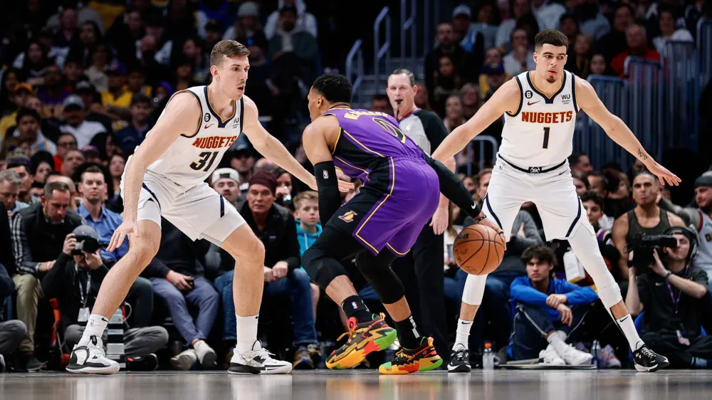Jan 9, 2023; Denver, Colorado, USA; Los Angeles Lakers guard Russell Westbrook (0) controls the ball as Denver Nuggets forward Vlatko Cancar (31) and forward Michael Porter Jr. (1) guard in the third quarter at Ball Arena. Mandatory Credit: Isaiah J. Downing-USA TODAY Sports