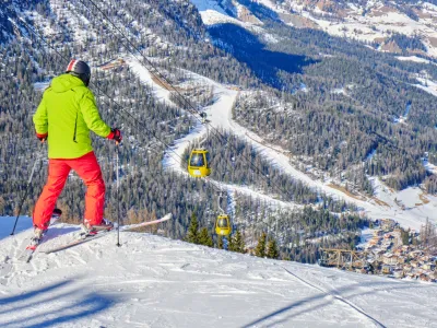 Alta Badia, Italy - January 21, 2020: Skier preparing to drop into a red ski run above La Villa village, South Tyrol, in Dolomites, Italy.