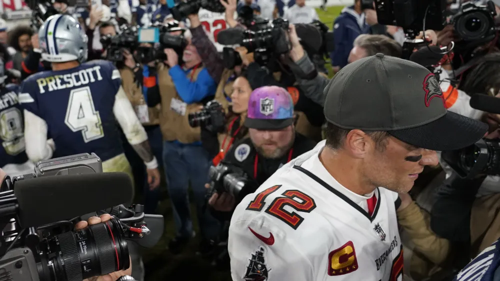 Tampa Bay Buccaneers quarterback Tom Brady (12) leaves the field after speaking with Dallas Cowboys quarterback Dak Prescott (4) after an NFL wild-card football game, Monday, Jan. 16, 2023, in Tampa, Fla. The Dallas Cowboys won 31-14. (AP Photo/Chris Carlson)