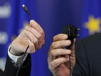 European Commissioner for Industry and Entrepreneurship Antonio Tajani and Bridget Cosgrave (L), Director General of DigitalEurope, display an harmonised mobile phone charger during a news conference at the EU Commission headquarters in Brussels February 8, 2011.  REUTERS/Francois Lenoir (BELGIUM - Tags: BUSINESS IMAGES OF THE DAY) - GM1E7281SMZ01