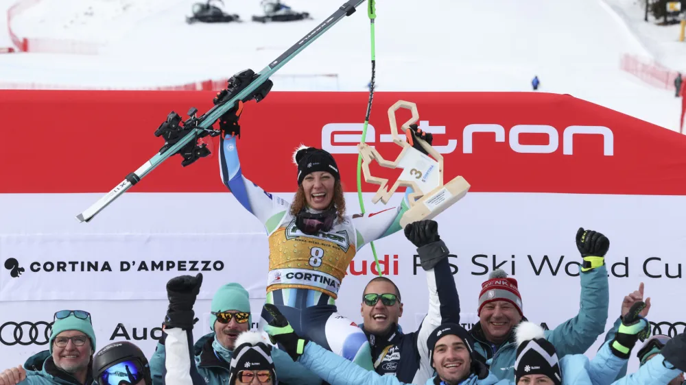 Slovenia's Ilka Stuhec celebrates with her team after winning an alpine ski, women's World Cup downhill race, in Cortina d'Ampezzo, Italy, Saturday, Jan. 21, 2023. (AP Photo/Alessandro Trovati)